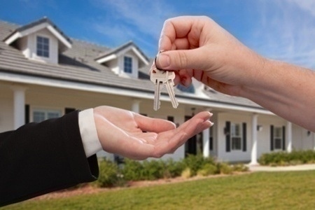 Handing Over the House Keys in Front of a Beautiful New Home.