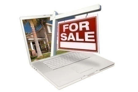 Home for Sale Sign & New Home on Laptop Isolated on a White Background.