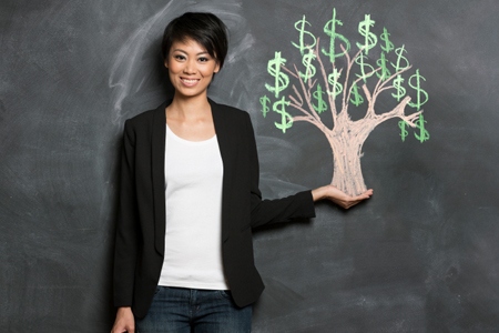 Asian woman and chalk money tree drawing on blackboard.