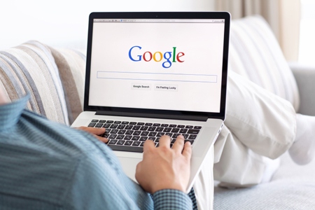 man sitting at the MacBook retina with site Google on the screen