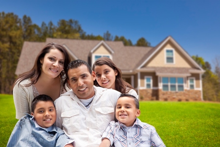 Happy Young Hispanic Family in Front of Their New Home.