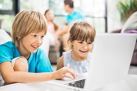 Children using laptop at home.