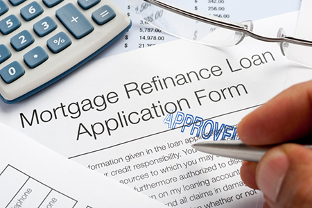 Approved Mortgage Refinance Application Form with pen, calculato