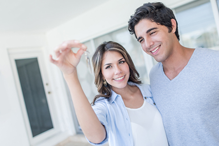 Couple holding keys to their new house