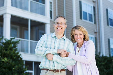 Mature couple in front of apartment building