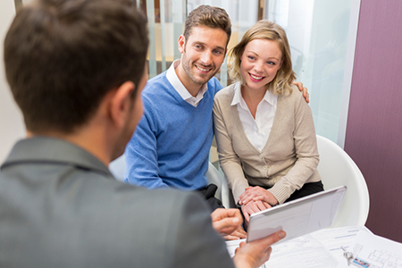 Young couple meeting real-estate showing a investment project on