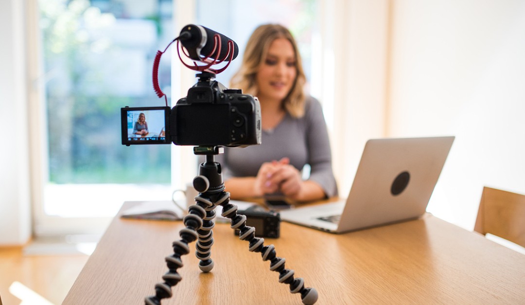 Woman doing a video with camera and shotgun microphone.